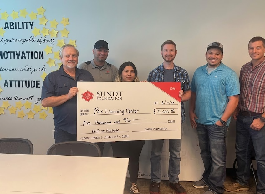 PAX Learning Center receiving a large donation check